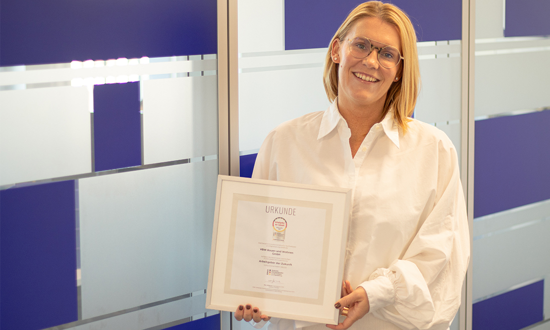 Lena Winkler, Abteilungsleiterin für Personal & Organisation, hält stolz die Auszeichnung zum Arbeitgeber der Zukunft in den Händen.