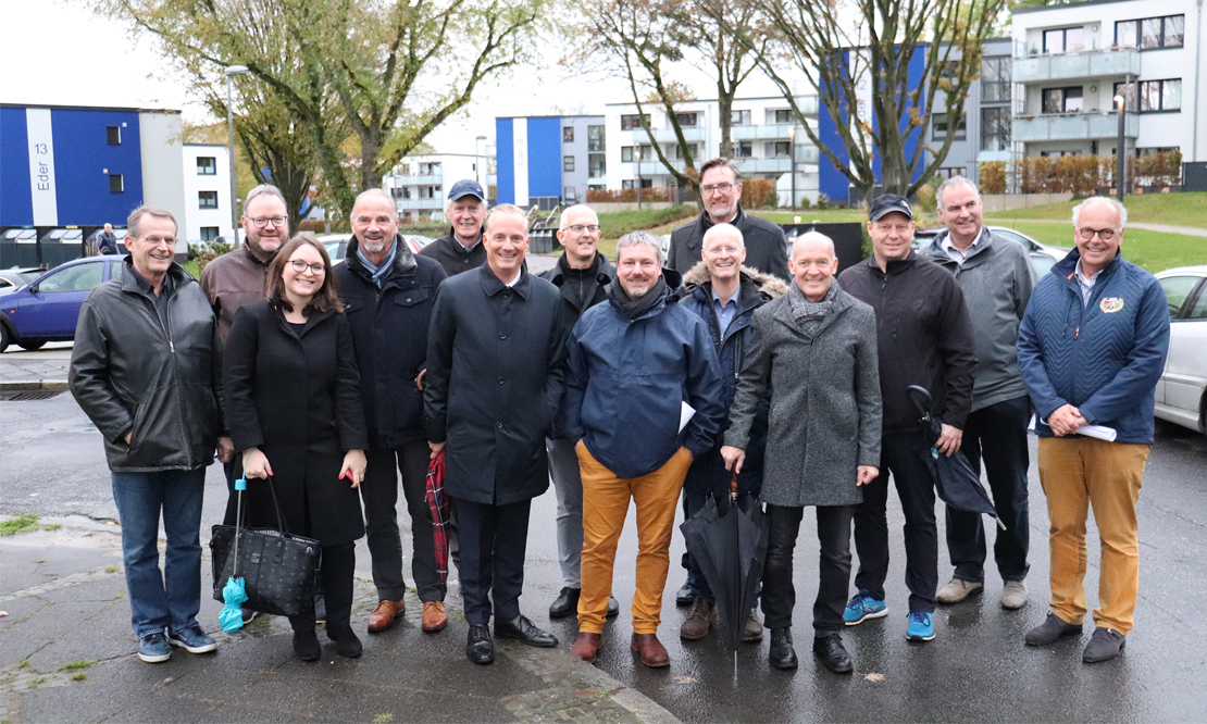 Ein Gruppenbild des europäischen Tischs vor der Kulisse der Flüssesiedlung